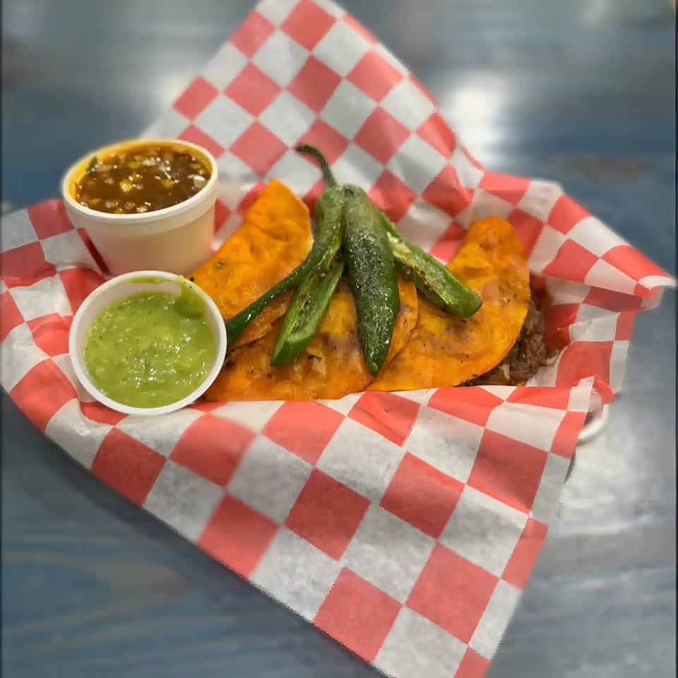 Three Oscar's Taco Shop birria tacos with grilled jalapeños, red salsa, and green salsa.
